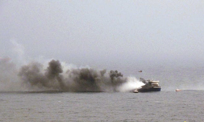 In this image provided by the Italian Navy, smoke billows from the Italian-flagged Norman Atlantic after it caught fire in the Adriatic Sea, Sunday, Dec. 28, 2014. A fire erupted on a ferry carrying 478 people from Greece to Italy on Sunday, leaving one person dead and trapping hundreds on top decks as gale-force winds and choppy seas hampered evacuation. The Italian Navy said that the victim and an injured person were transported by helicopter to the southern Italian city of Brindisi on Sunday evening. Greek and Italian rescue helicopters and vessels struggled to reach the crippled ferry, battered by 90 kilometer per hour (55 mph) winds that pushed it toward the Albanian coast. (AP Photo/Italian Navy)