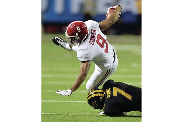 Alabama Crimson Tide wide receiver Amari Cooper is brought down by Missouri Tigers defensive back Kenya Dennis during the first half of the 2014 SEC Championship on Dec. 6 at the Georgia Dome in Atlanta. (Brant Sanderlin/TNS)