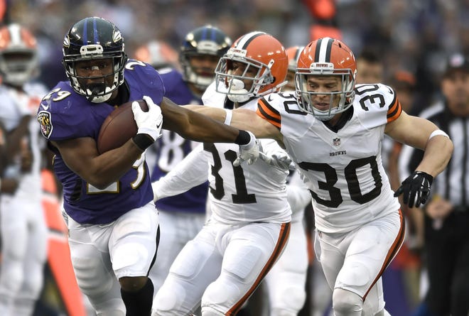 Baltimore Ravens running back Justin Forsett, left, rushes past Cleveland Browns free safety Jim Leonhard (30) and strong safety Donte Whitner in the second half of an NFL football game, Sunday, Dec. 28, 2014, in Baltimore. (AP Photo/Gail Burton)
