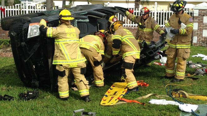 Delray Beach firefighters examine an overturned SUV after a two-vehicle crash on West Atlantic Avenue on Monday morning. (Photo courtesy of Delray Beach Fire Rescue)