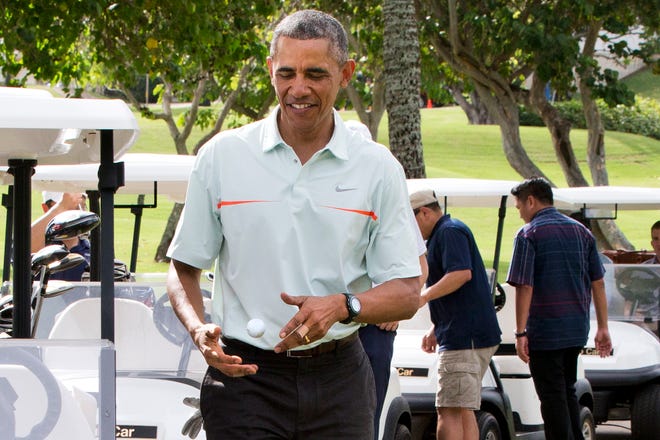 Surrounded by Secret Service agents, President Barack Obama tosses a golf ball between his hands after finishing the 18th hole of a game of golf with Malaysian Prime Minister Najib Razak last Wednesday.