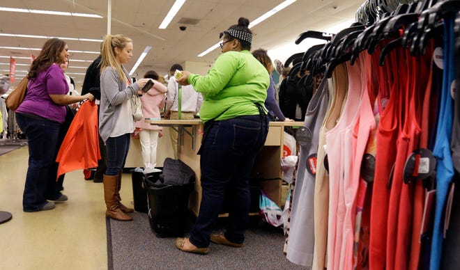Shoppers stand in line on Dec. 26 at Nordstrom Rack in Schaumburg, Ill. The Conference Board said Tuesday its consumer confidence index climbed to 92.6 this month from a revised 91 in November.