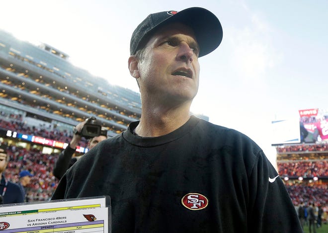 In this Dec. 28, 2014, file photo, San Francisco 49ers head coach Jim Harbaugh walks off the field after an NFL football game against the Arizona Cardinals in Santa Clara, Calif. Harbaugh will return to his alma mater as the University of Michigan's football coach. (AP Photo/Marcio Jose Sanchez, File)