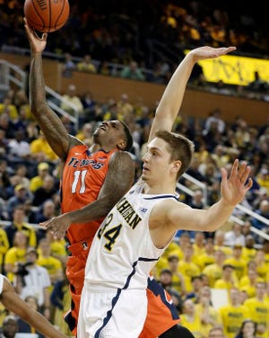 Illinois guard Aaron Cosby (11) makes a layup as Michigan forward Mark Donnal (34) defends during the first half of an NCAA college basketball game in Ann Arbor, Mich., Tuesday, Dec. 30, 2014.