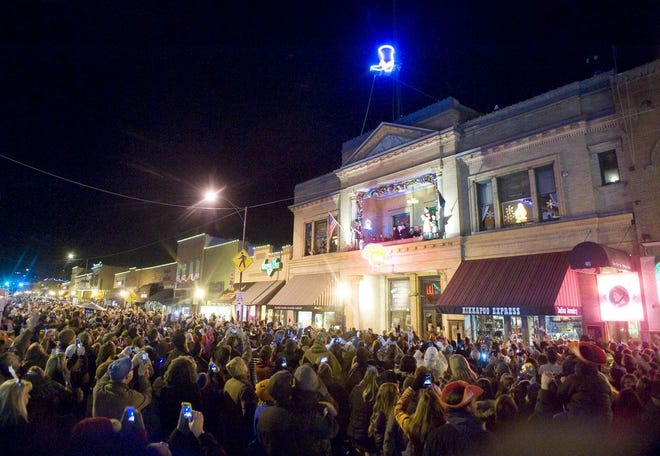 In this Dec. 31, 2013 photo, the crowd cheers as a lighted cowboy boot drops to the roof of the Palace Saloon New Year's Eve on Whiskey Row in downtown Prescott, Ariz. Televised images every year of New York City’s glittery ball drop in Times Square have become inextricably linked with New Year’s Eve. But Times Square isn’t the only place to ring in the new year with an object dropping from the sky at midnight. (AP Photo/The Daily Courier, Les Stukenberg)