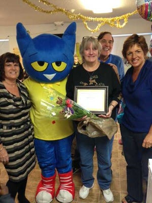 Katherine Hall at Castle Brook Academy was named Preschool Teacher of the Year by the Early Learning Coalition of North Florida. From left: Marriane Brewer, Pete the Cat, Don Sutton, Owner Crowned Hart Preschools, Joan Whitson, ELC Early Literacy Coordinator, with Katherine Hall (Ms. Susie) in front holding flowers.