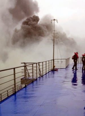 In this image taken from a Dec. 28, 2014, video and made available Wednesday, Dec. 31, 2014, smoke billows from the Italian-flagged Norman Atlantic ferry that caught fire in the Adriatic Sea. More than 400 people were rescued from the ferry, most in daring, nighttime helicopter sorties that persisted despite high winds and seas, after a fire broke out before dawn Sunday on a car deck. Both Italian and Greek authorities have announced criminal investigations into the cause of the blaze. Italian authorities warned Tuesday that more bodies will likely be found when the blackened hulk of a Greek ferry is towed to Italy, as part of a criminal investigation into the fire that engulfed the ship at sea, killing at least 11 of the more than 400 people on board.