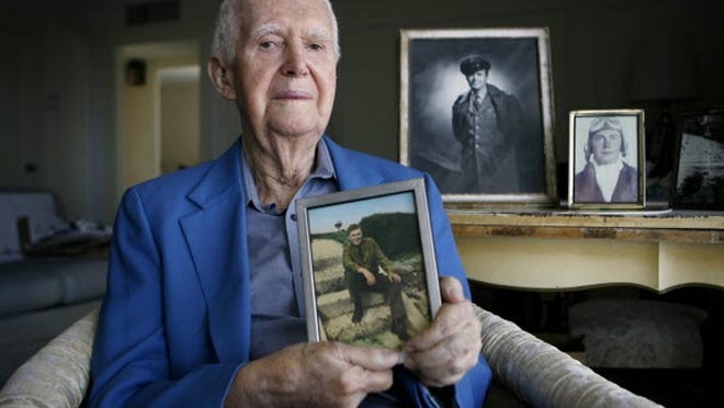 Frank Randolph of Palm Beach, holding a photo of himself taken at Pearl Harbor, remembers the attack 'like yesterday.’ Then 22, he was wounded at Hickam Field. In 1961, he left the Air Force as a colonel.