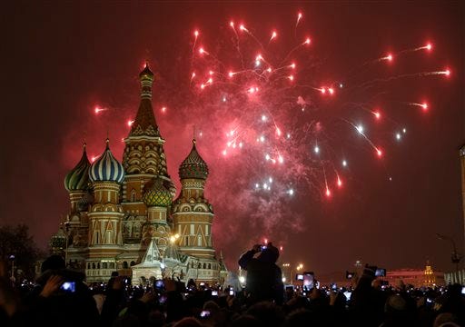 People photograph fireworks as they celebrate the New Year in Red Square in Moscow, Russia, Thursday, Jan. 1.