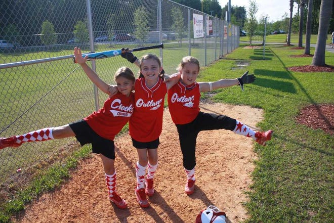 Three members of the Jax Fusion '03 10U Softball Team have fun posing for a photo. They are (l to r) Madison Bratek, Erin Wagner and Kylie Hammonds.