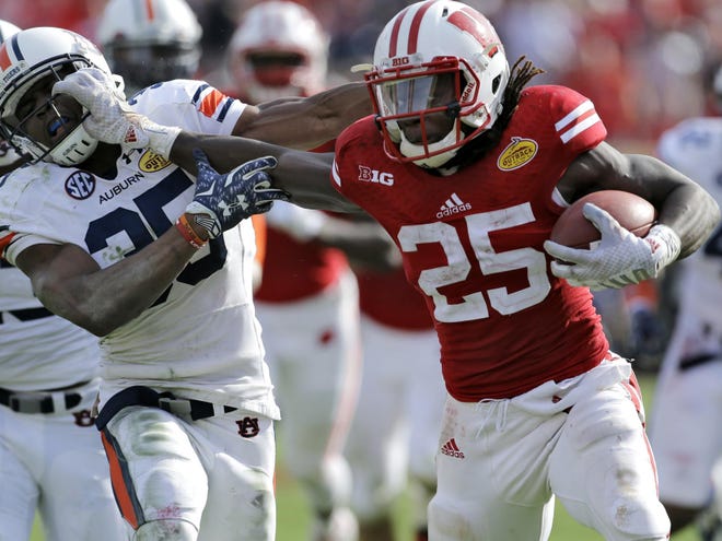 Wisconsin running back Melvin Gordon (25) stiff arms Auburn defensive back Jermaine Whitehead (35) on a 53-yard touchdown run during the third quarter of the Outback Bowl Thursday afternoon in Tampa.
