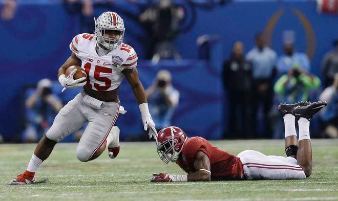 Ohio State running back Ezekiel Elliott runs by Alabama defensive back Eddie Jackson in the first half on Thursday. Elliott rushed for 230 yards on 20 carries and two TDs.