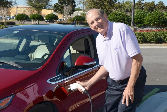 Stuart Smith “fills up” his Chevy Volt at one of Destin Commons’ free electric car charging stations on the north side of Uncle Buck’s Fishbowl & Grill.
