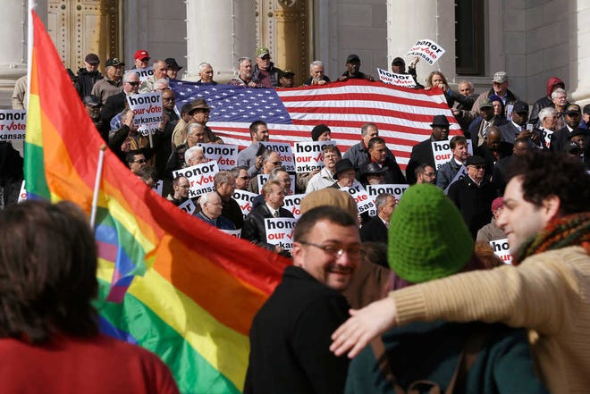 FILE - In a Wednesday, Nov. 19, 2014 file photo, supporters of Arkansas' law banning same sex marriage, top, hold a rally at the Arkansas state Capitol in Little Rock, Ark., as protestors carry flags and shout. An gay rights ordinance passed in August by the city council in Fayetteville, Ark., was repealed by voters on Dec. 10. Even as same-sex marriage edges closer to becoming legal nationwide, gay-rights advocates face other challenges in 2015 that may not bring quick victories. (AP Photo/Danny Johnston, File)