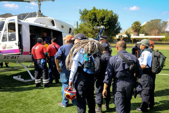 Police and specialized rescue personnel prepare to board a helicopter belonging to the state of Morelos government near the town of Tepoztlan, Mexico, Friday, Jan. 2, 2015 as they continue to search for Hari Simran Singh Khalsa, 25, an American who has been missing in these mountains of central Mexico for four days after going on a hike. State authorities confirmed later on Friday that the life-less body of Hari Simran Singh Khalsa was found at the bottom of a ravine. (AP Photo/Tony Rivera)