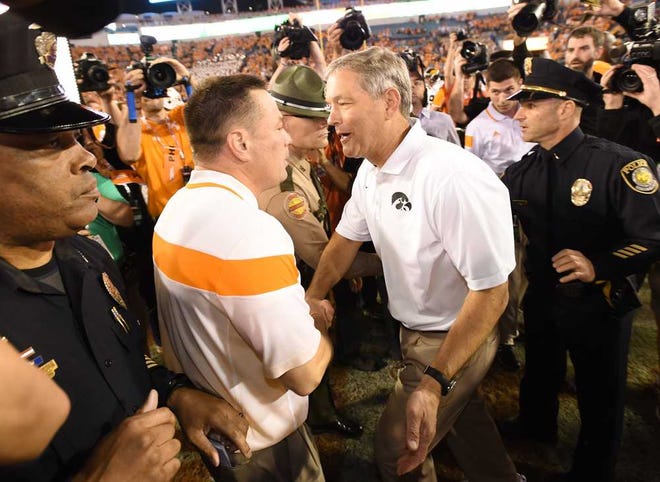 Bob.Self@jacksonville.com Tennessee coach Butch Jones (center) and Iowa coach Kirk Ferentz talk after the TaxSlayer Bowl on Friday at EverBank Field. The Volunteers are a program on the rise, but the Hawkeyes are struggling.