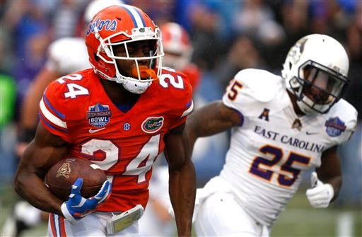 Florida defensive back Brian Poole (24) returns an interception for a touchdown during the first half of an Birmingham Bowl NCAA college football game against East Carolina Saturday in Birmingham, Ala.