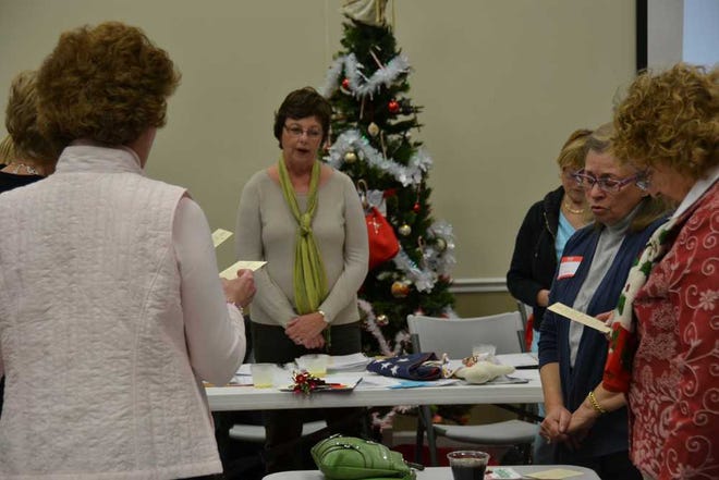 Anne Redlus, chairperson for the new GFWC Woman's League of the Low Country, leads the group in reciting the collect for members of GFWC clubs.