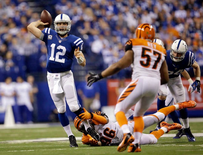 Indianapolis quarterback Andrew Luck throws a touchdown pass to Donte Moncrief before he is brought down by Cincinnati's Carlos Dunlap during the third quarter. He completed 31 of 44 passes for 376 yards in the Colts' win.