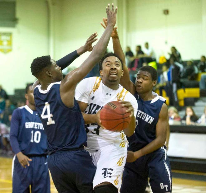 Evans' Trevon Caberrus tries to bet off a shot as Grovetownls Solomon Gause (left) and Brandon Oaks defend the basket on Dec. 30, 2014. Photo by Jim Blaylock