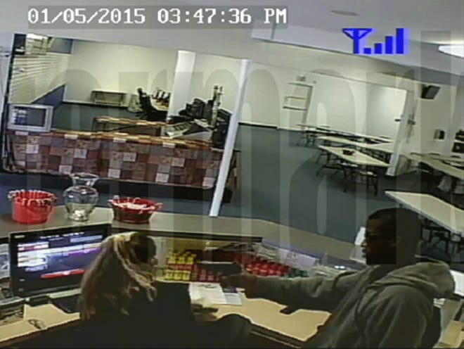 A surveillance video grab shows a man pointing a gun in a robbery at Orange Park Bingo on Monday, Jan. 5, 2015.