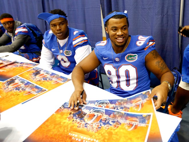 Bullard (90) and Leon Orr laugh while signing autographs during Fan Day at the O'Connell Center in August.
