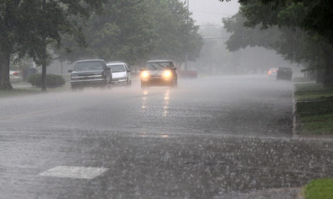 A car drives along 17th Avenue during a heavy rain storm Friday morning, May 24, 2014. About 1 1/2 inches of rain fell in the Hutchinson area.