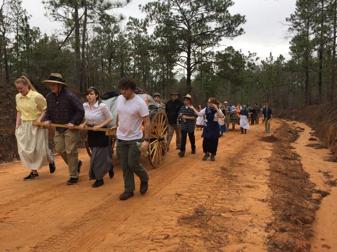 Local teens of the Church of Jesus Christ of Latter-day Saints pull their handcarts filled with gear dur-ing a three-day trek through the Blackwater Forest in commemoration of the 1856 migration of their ancestors to Salt Lake City.