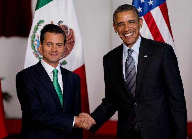 In this Feb. 19, 2014 file photo, Mexico's President Enrique Pena Nieto, left, and President Barack Obama pose for photographers at the North American Leaders Summit in Toluca, Mexico. Obama is hosting Nieto at the White House Tuesday, Jan. 6, 2015, looking to his southern neighbor for help implementing his changing policies on immigration and Cuba.