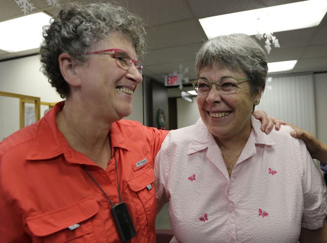 Deborah Shure, 66, left, hugs her partner Aymarah Robles, 60, as they wait to apply for a marriage license at the Miami-Dade County Clerk of Courts office on Monday.