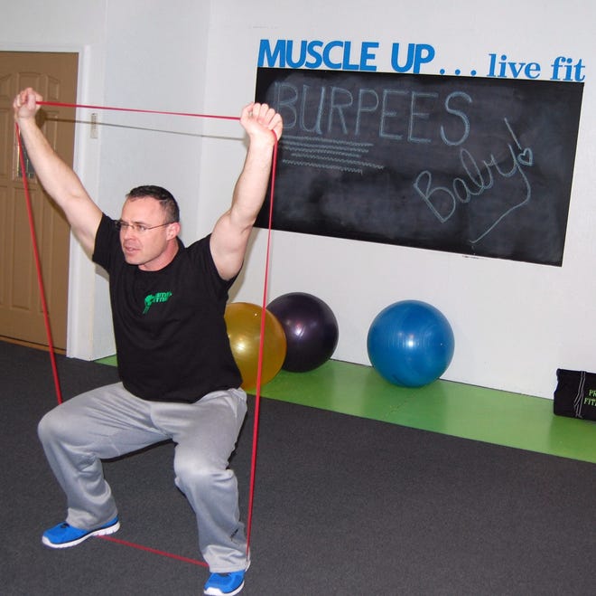Fitness trainer James Campbell illustrates how he uses resistance bands to train clients. NANCY HASTINGS PHOTO