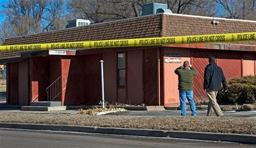 Colorado Springs officials investigate the scene of an explosion Tuesday, Jan. 6, 2015, at a building in Colorado Springs, Colo. Authorities are investigating whether a homemade explosive set off outside the building that houses a barber shop and the Colorado Springs chapter of the NAACP was aimed at the nation's oldest civil rights organization. (AP Photo/The Colorado Springs Gazette, Christian Murdock )