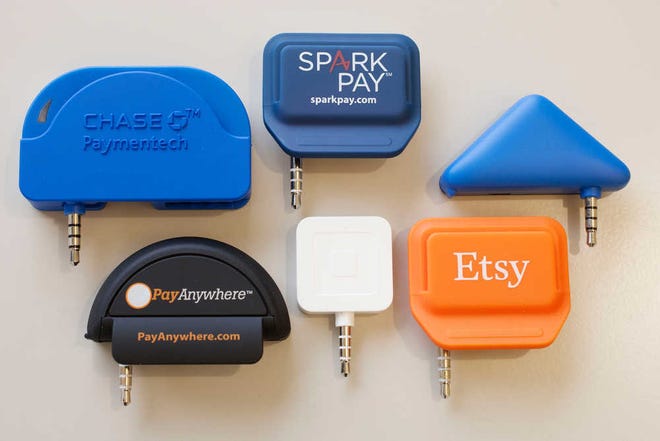 This Tuesday, Jan. 6, 2015 photo shows mobile credit card readers that connect into a smartphone, or tablet, and let business owners accept credit card payments, in New York. In the top row, from left, are readers from Chase Bank, Spark Pay, and PayPal. Bottom row, from left, are readers from Pay Anywhere, Square, and Etsy. (AP Photo/Mark Lennihan)
