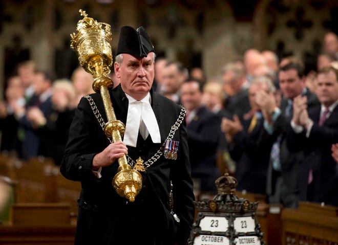 FILE - In a Thursday, Oct. 23, 2014 file photo, Sergeant-at-Arms Kevin Vickers receives a standing ovation as he enters the House of Commons in Ottawa. The Canadian Press reported Thursday, Jan. 8, 2015 that Vickers, hailed as a hero for killing the gunman who stormed Canada's parliament last year will be named ambassador to Ireland. (AP Photo/The Canadian Press, Adrian Wyld, File)