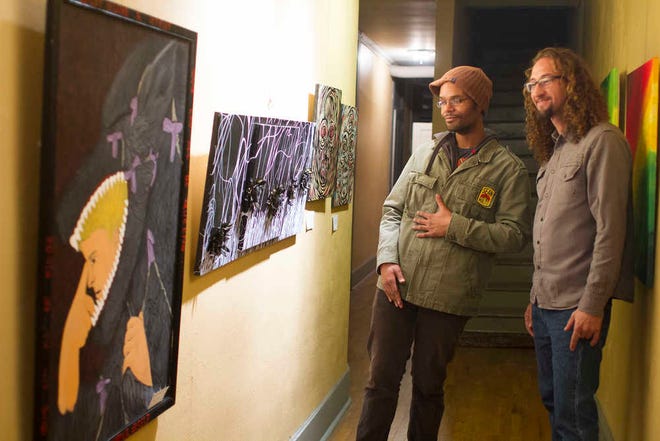 Artist Jordan Brookes, left, and Two Wolves Studio & Artist Den owner Alexander Lancaster view some of Brookes' artwork on display at the studio in the NOTO Arts District during the First Friday Artwalk in January.