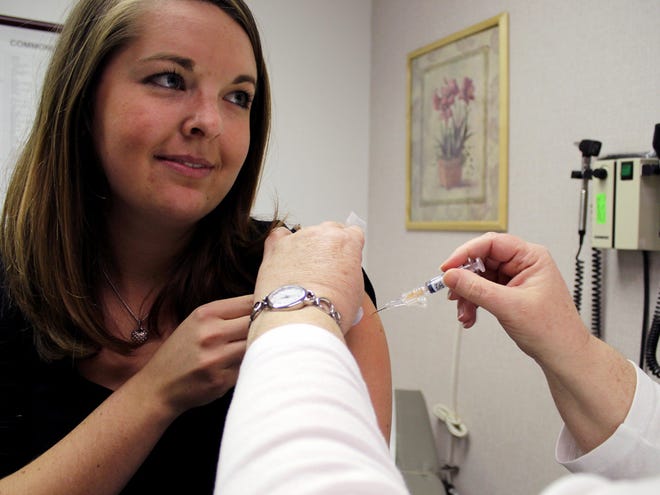 In this Jan. 22, 2014 file phto, Melissa Ray is administered a flu shot at the University of Florida Student Health Care Center.