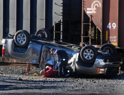 An injured man crawls from his vehicle after he collided with a train Thursday morning. Drew C. Wilson/Havelock News