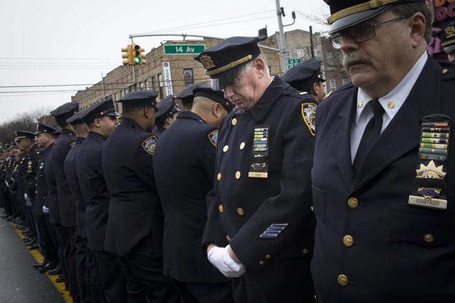 Some police officers turn their backs as Mayor Bill de Blasio speaks during the funeral of New York Police Department Officer Wenjian Liu at Aievoli Funeral Home on Jun 4. Liu and his partner, officer Rafael Ramos, were killed Dec. 20 as they sat in their patrol car on a Brooklyn street. The shooter, Ismaaiyl Brinsley, later killed himself. JOHN MINCHILLO/ASSOCIATED PRESS