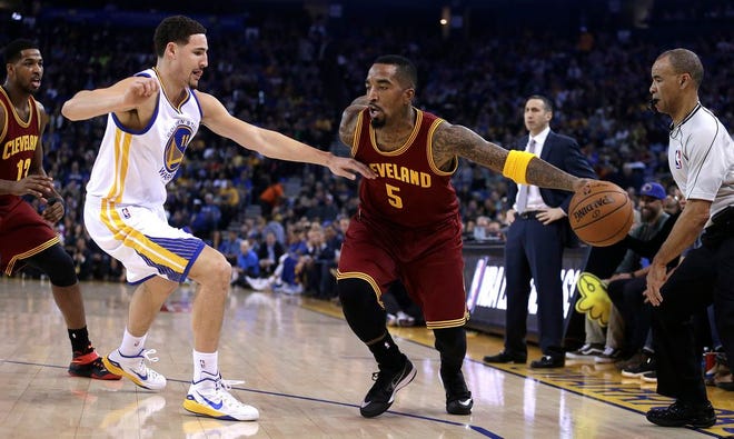 Cleveland Cavaliers' J.R. Smith, right, drives the ball against Golden State Warriors' Klay Thompson during the first half of Friday's game in Oakland, California.