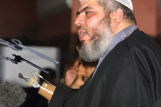 FILE - In this July 12, 2002 file photo, radical cleric Mustafa Kamel Mustafa, then known as Sheik Abu Hamza al-Masri, addresses a fundamentalist Islamic conference in London condemning what he said was oppression of Muslims in the West. Lawyers for the Egyptian Islamic cleric from London who was convicted of terrorism charges say Mustafa should be sentenced to less than life in prison, in part because prisons are not equipped to care properly for a man with no arms and other medical issues. Mustafa is set to be sentenced on Jan. 9, 2015, in New York. (AP Photo/Alistair Fuller, File)