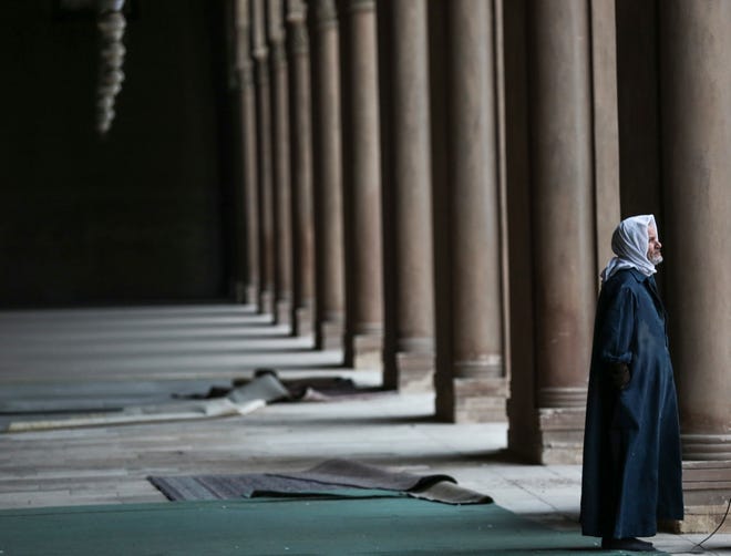 In this Friday, Jan. 9, 2015 photo, an Egyptian Muslim pauses inside Ibn-Tulun Mosque, one of the oldest mosques in Cairo, Egypt. Amid violence like the attack in Paris on a satirical newspaper over its depictions of the Prophet Muhammad, there's been increasing discussions among Muslims who say their community must re-examine their faith to modernize its interpretations and sideline extremists. There is a growing debate within Islam about whether and how to reject a radical minority that some fear is dragging them into conflict and wrecking the faith.