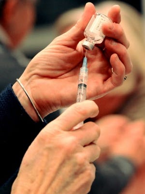 A nurse prepares to administer the flu vaccine at a local clinic. Cape Cod Times file photo