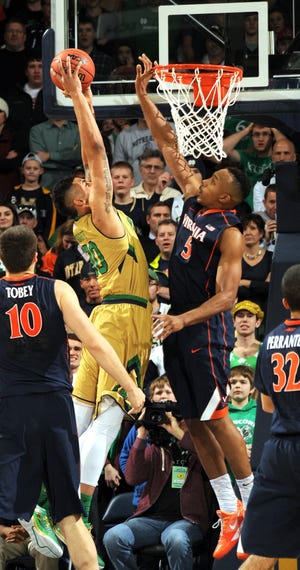 Notre Dame forward Zach Auguste, left, puts up a shot as Virginia forward Darion Atkins defends in the first half Saturday in South Bend, Ind. (AP Photo/Joe Raymond)