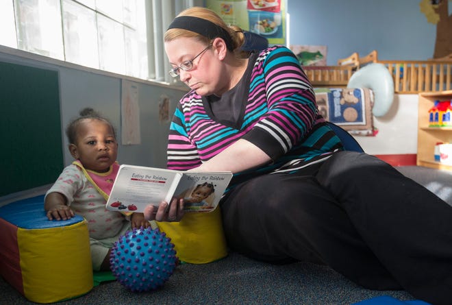 Christine Beck (right) reads “Eat the Rainbow” to Journey Ellis, 10 months, Friday, Jan. 9, 2015, at Circles of Learning in Rockford.