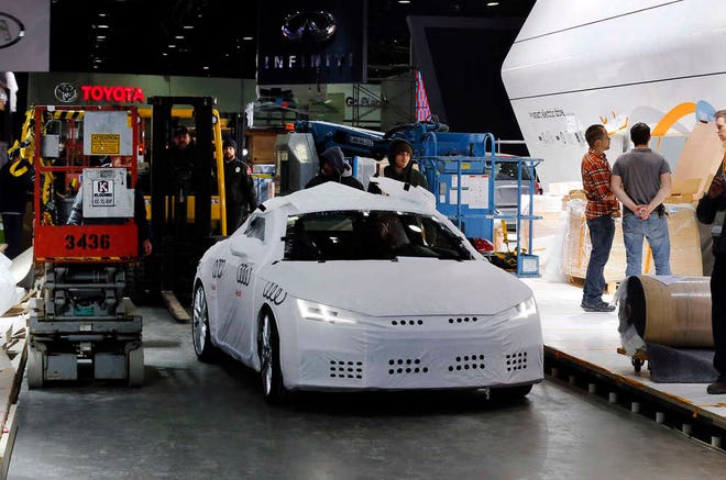 An Audi automobile moves through set up for the upcoming North American International Auto Show in Detroit Thursday, Jan. 8, 2015. (AP Photo/Paul Sancya)
