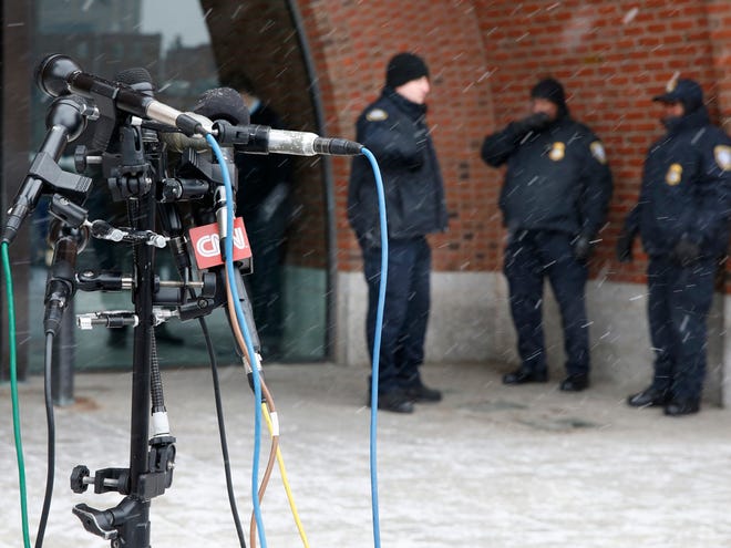 Police stand guard behind television microphones set up outside the federal courthouse in Boston,Tuesday, Jan. 6, 2015, on the second day of jury selection in the trial of Boston Marathon bombing suspect Dzhokhar Tsarnaev.