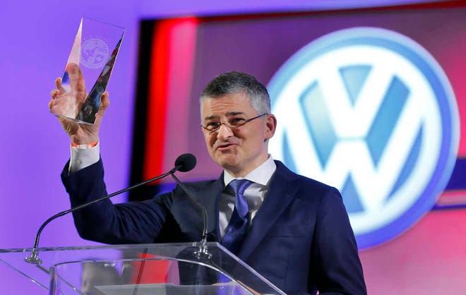 Michael Horn, president and CEO of Volkswagen Group of America, Inc., holds up the trophy for the North American Car of the Year award for the Volkswagen Golf at media previews for the North American International Auto Show in Detroit.
