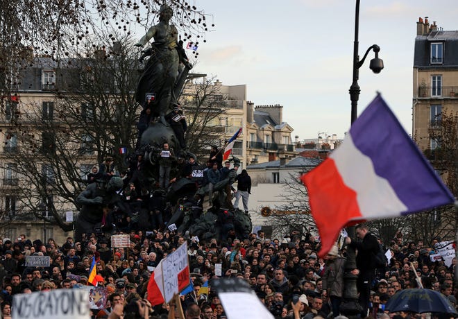 People wave national flags and hold placards that read "I am Charlie" at the Place de la Nation in Paris, France, Sunday, Jan. 11, 2015. More than 40 world leaders, their arms linked, marched through Paris Sunday to rally for unity and freedom of expression and to honor 17 victims of three days of terrorist attacks.