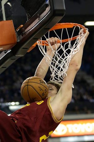Cavaliers center Timofey Mozgov hangs on the rim after a dunk against the Sacramento Kings on Sunday.