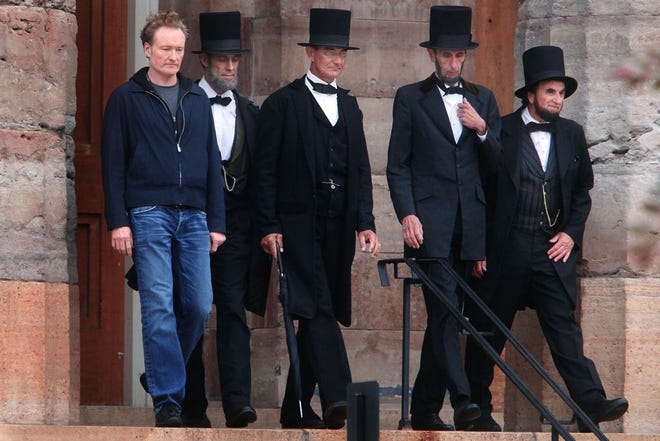 Comedian and talk show host Conan O'Brien walks down the north stairs of the Old State Capitol in Springfield along with four Abraham Lincoln presenters while a filming segment on Thursday, May 31, 2012. File/SJ-R